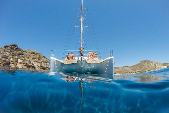 Santorini Catamaran Cruise with Fresh Meal and Open Bar - Passing the Akrotiri Lighthouse and the rocky landmarks you don’t reach by car
